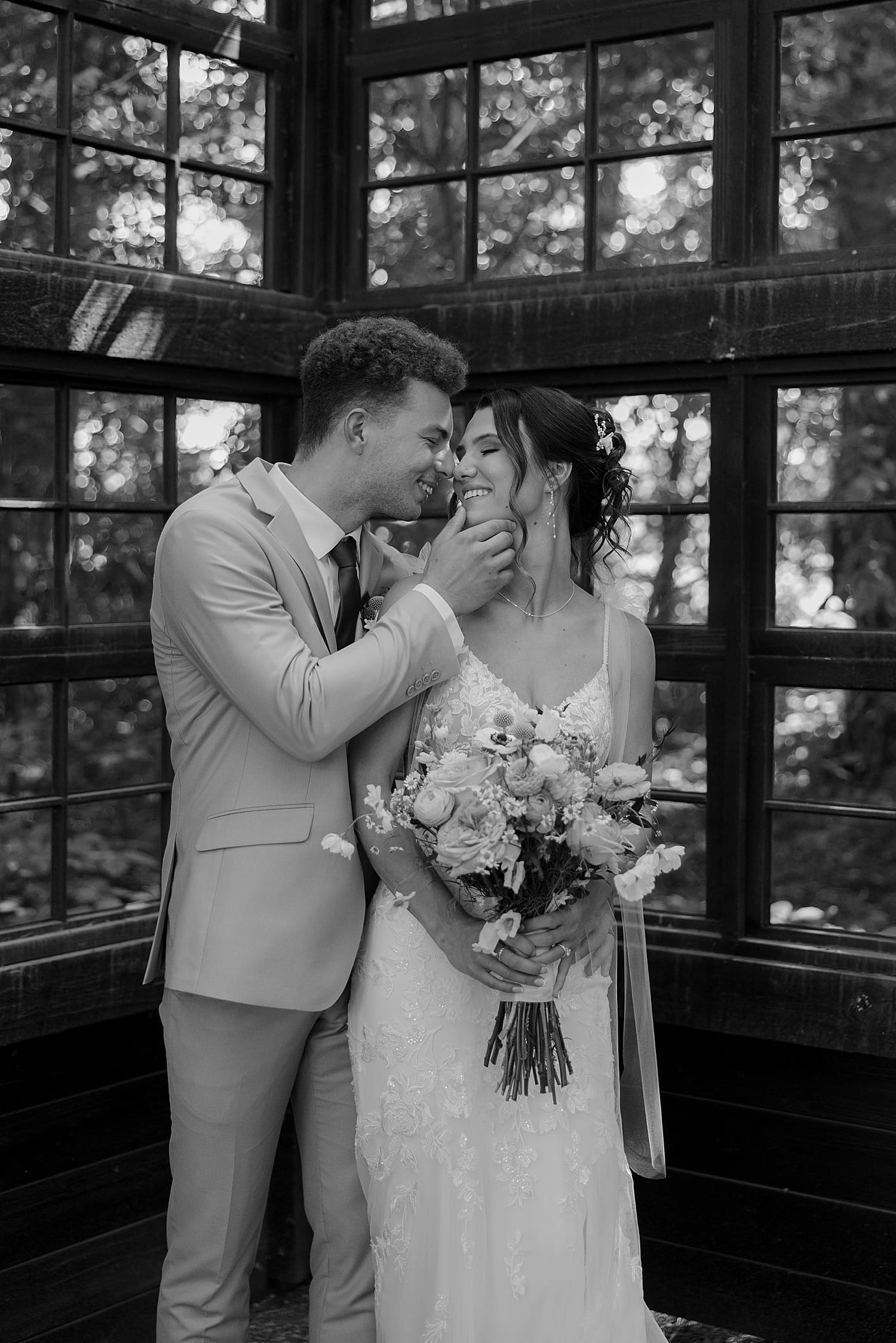 groom tips his wife's face in for a sweet kiss by Wisconsin wedding photographer