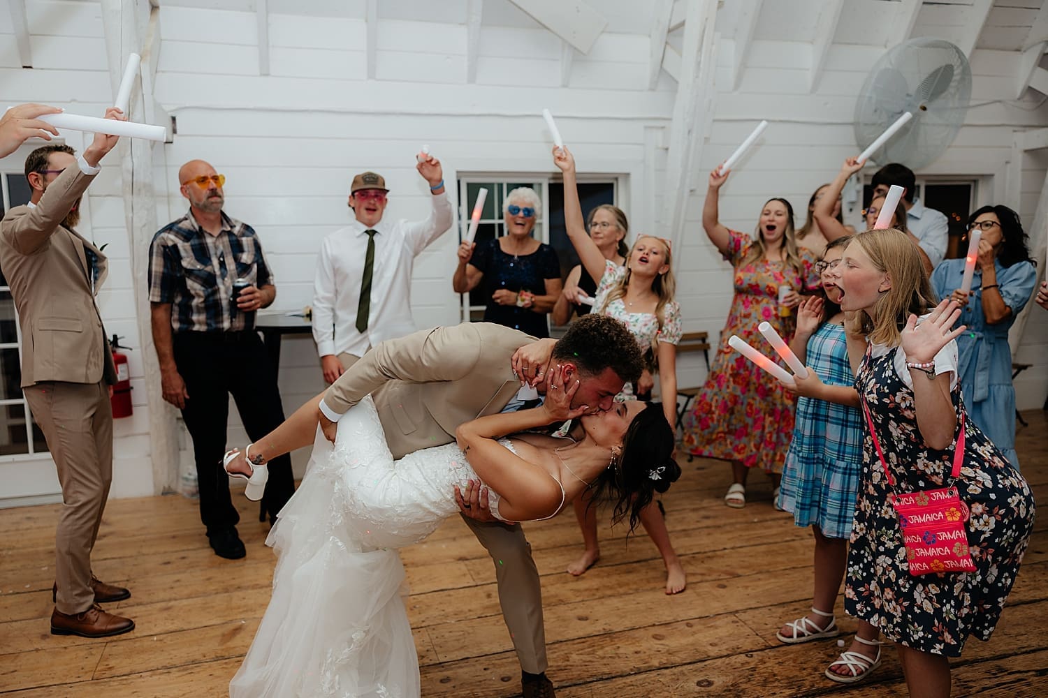 husband dips his new wife for a kiss on dance floor at reception by Rose and Oak Photography