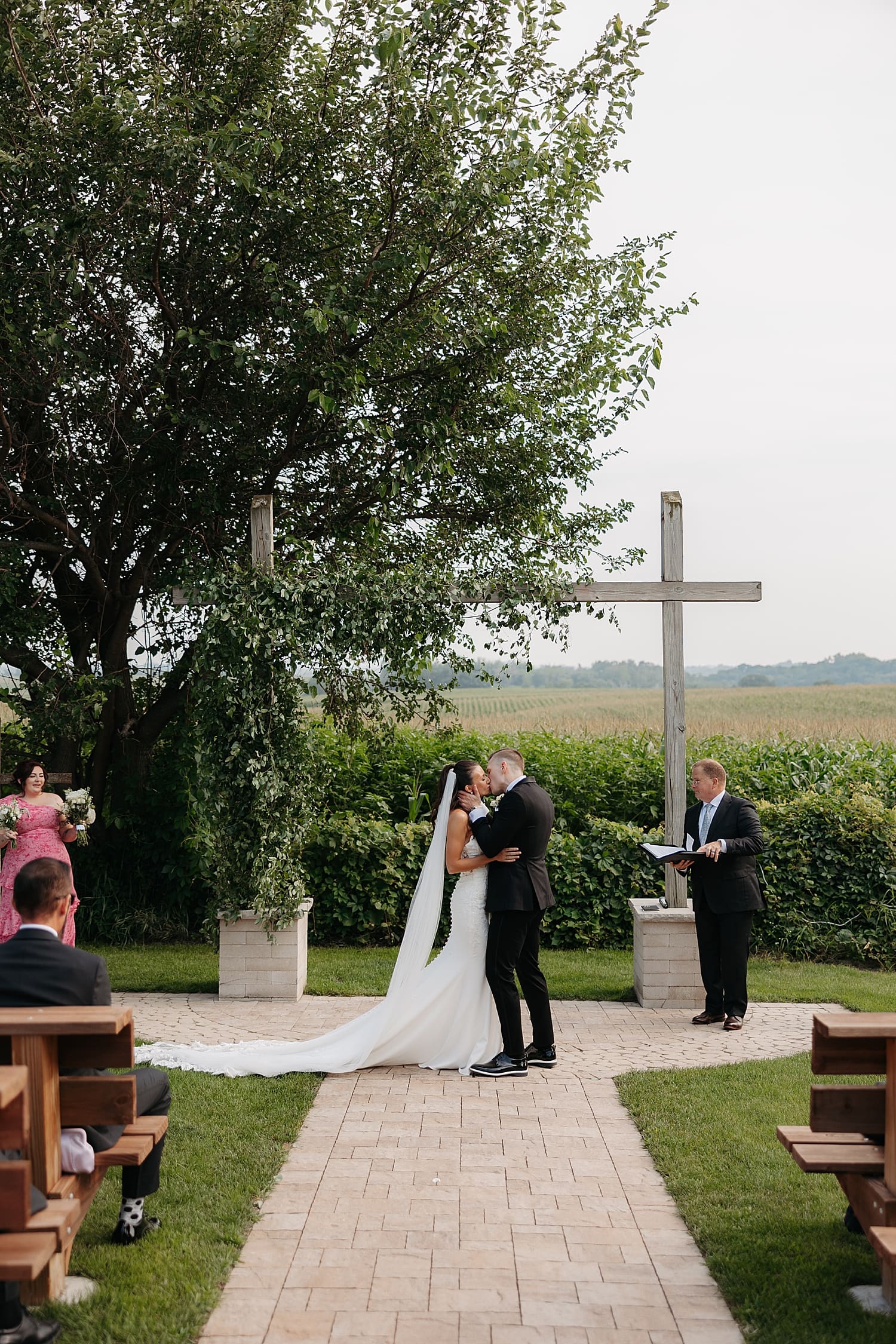 newlyweds share first kiss by outdoor alter by Rose and Oak Photography