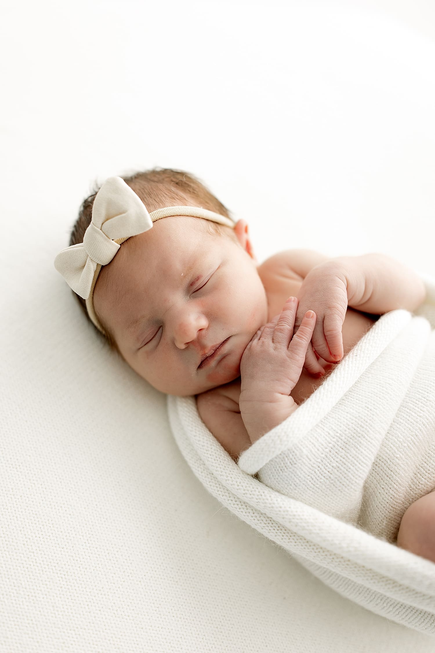 tiny infant wrapped in white for studio newborn session