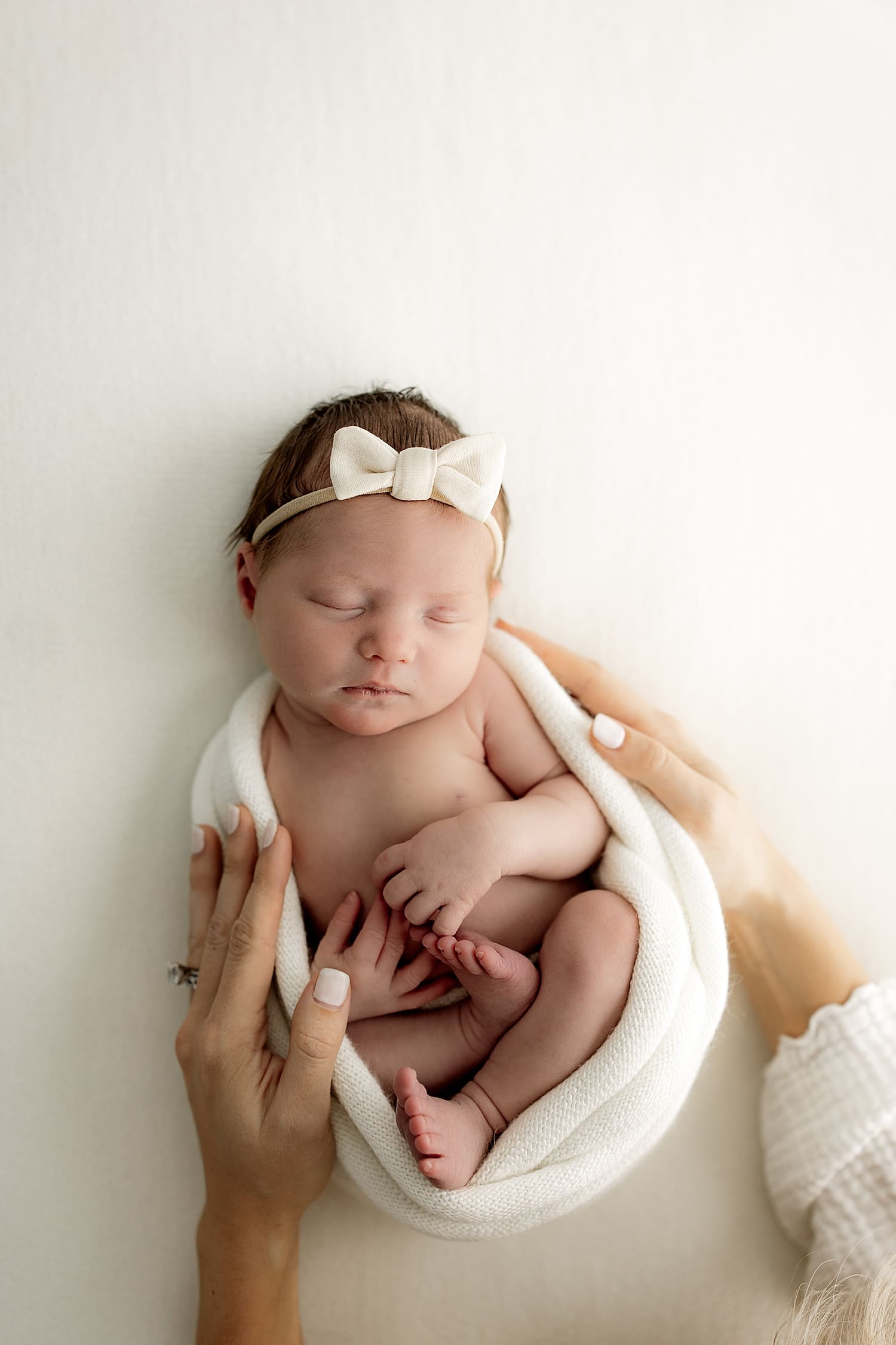 infant on white backdrop for studio newborn session