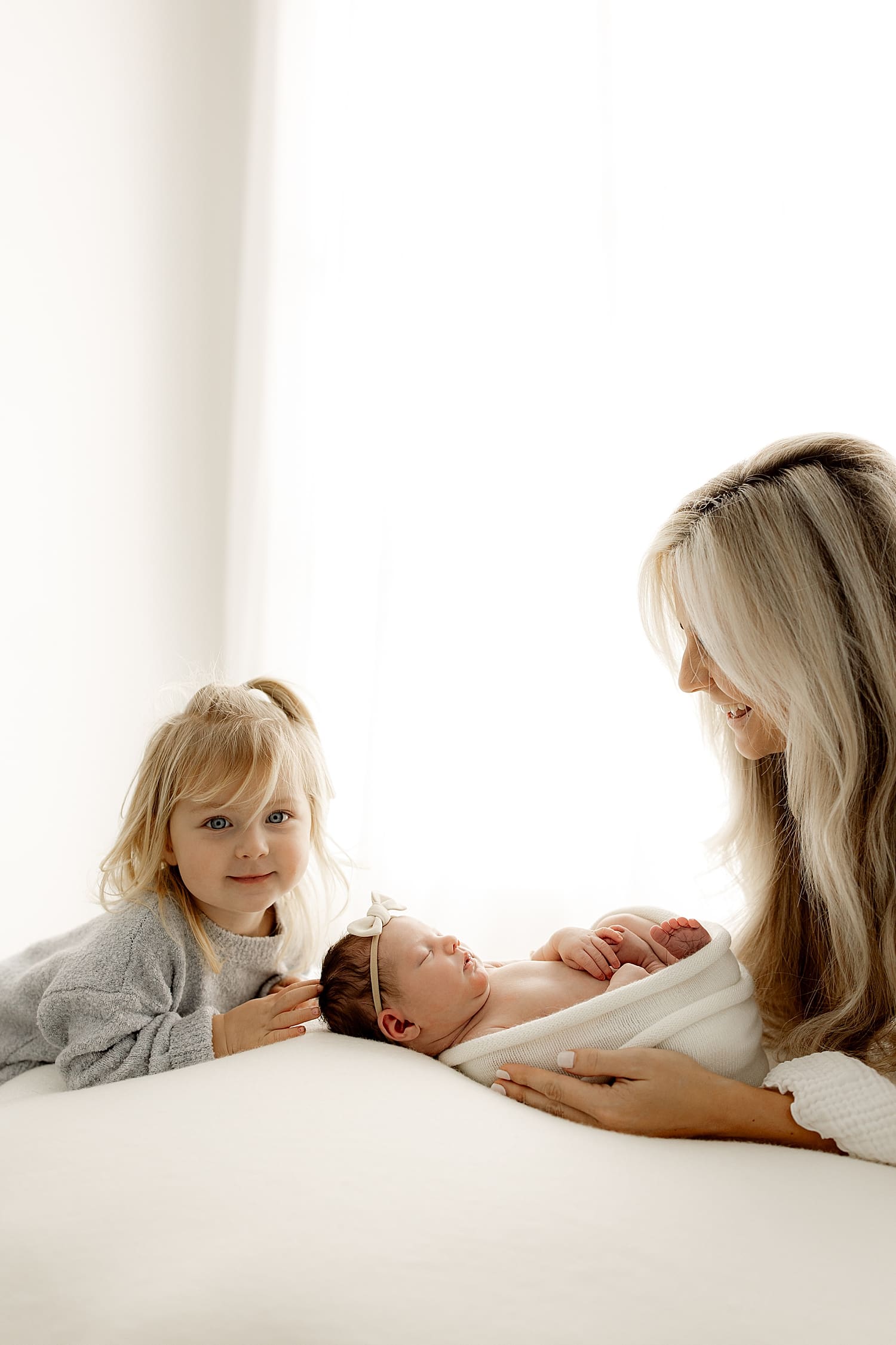 toddler sits down next to new addition by Wisconsin family photographer