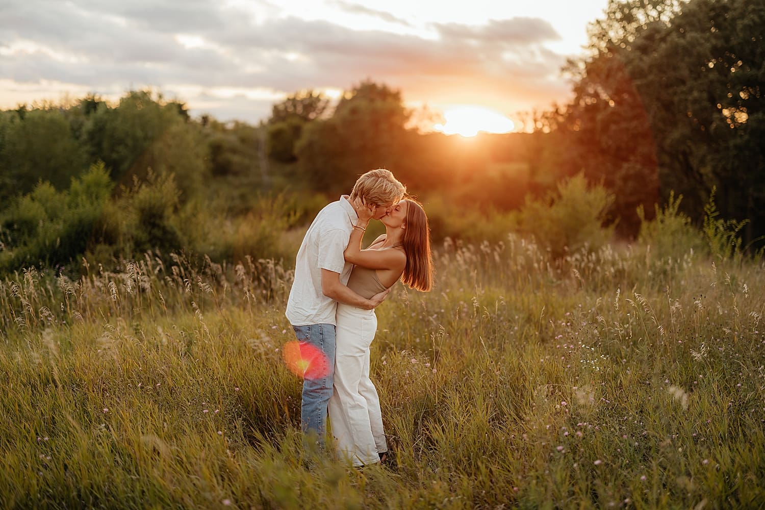 engaged couple kiss during sunset outside by Rose and Oak Photography