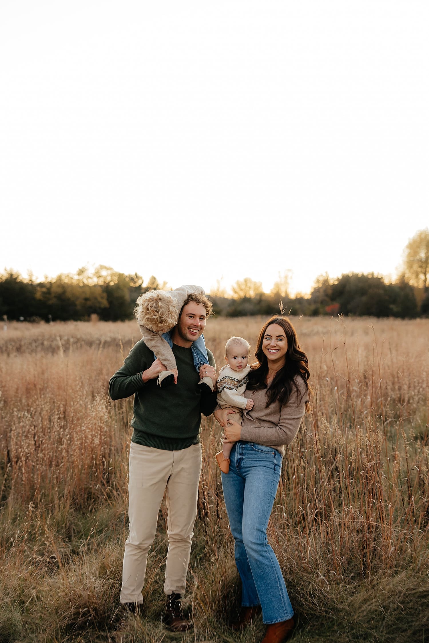 parents hold their kids during golden hour by Rose and Oak Photography