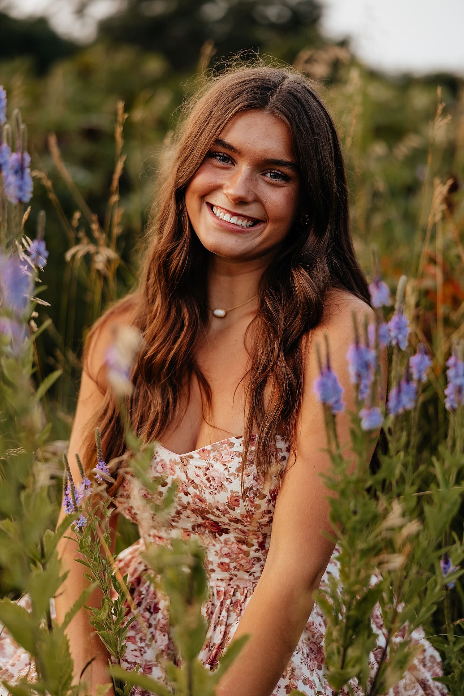 girl sits in field of flowers in fading light by Rose and Oak Photography
