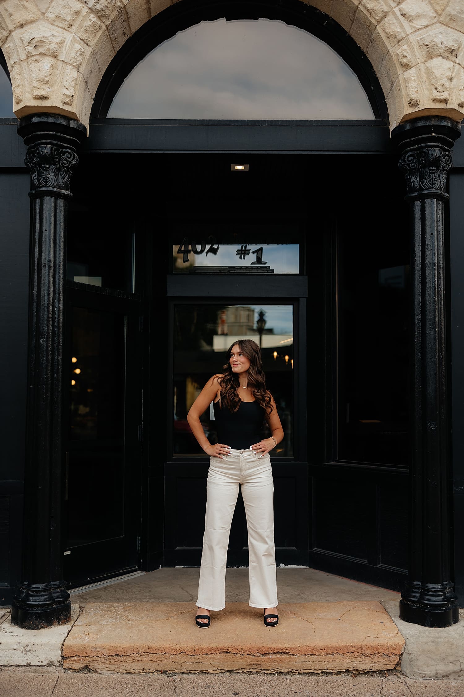 woman in white pants stand in doorway by Rose and Oak Photography