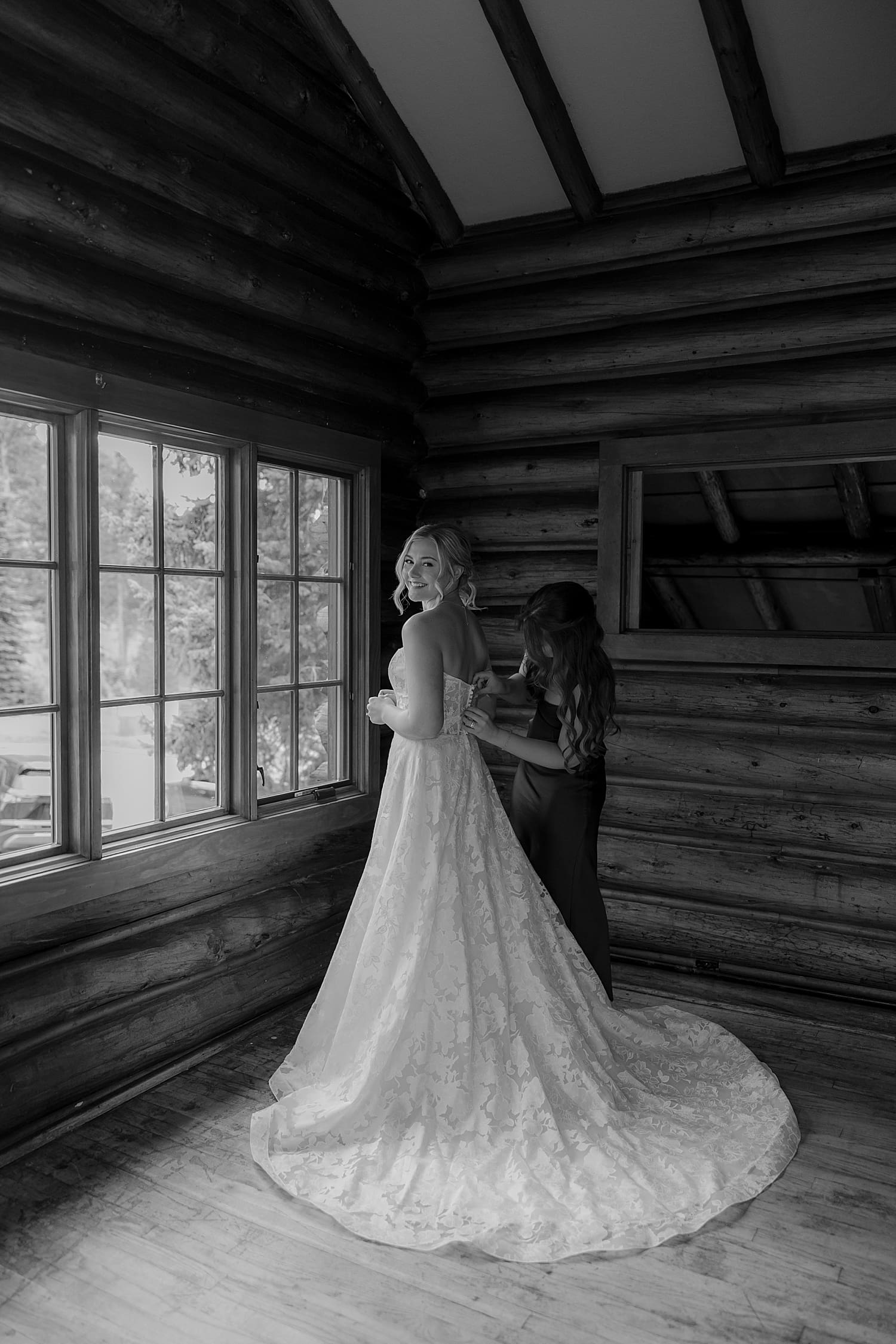 woman getting zipped into long white bridal gown by Wisconsin wedding photographer