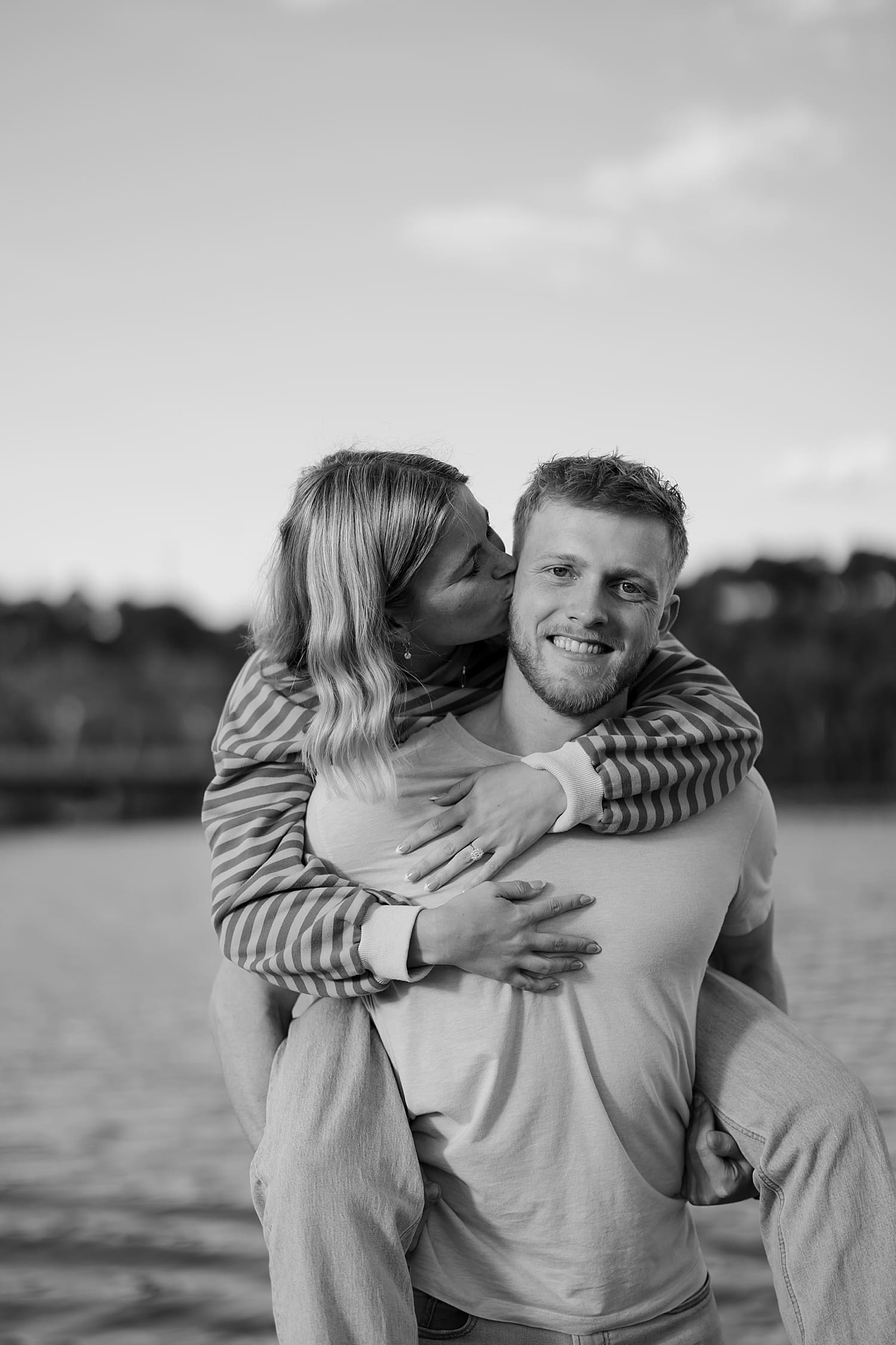 woman holds onto man's back and kisses his temple by Wisconsin wedding photographer