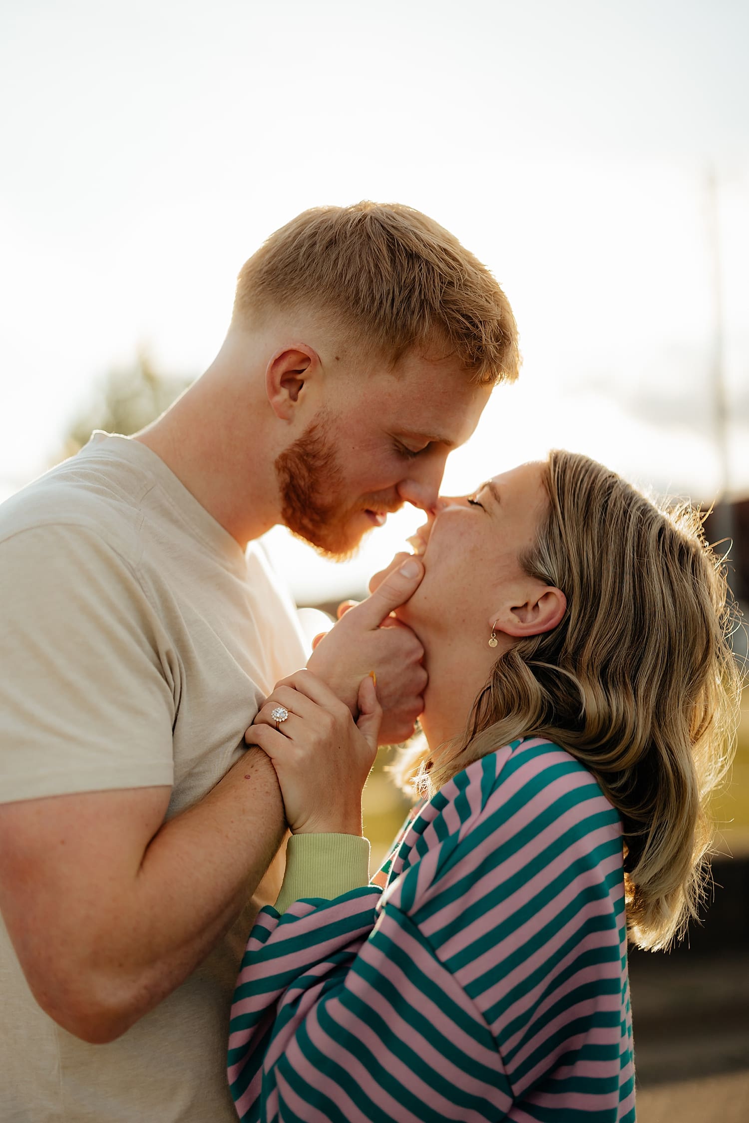 newly engaged couple leans in for a kiss for waterfront proposal