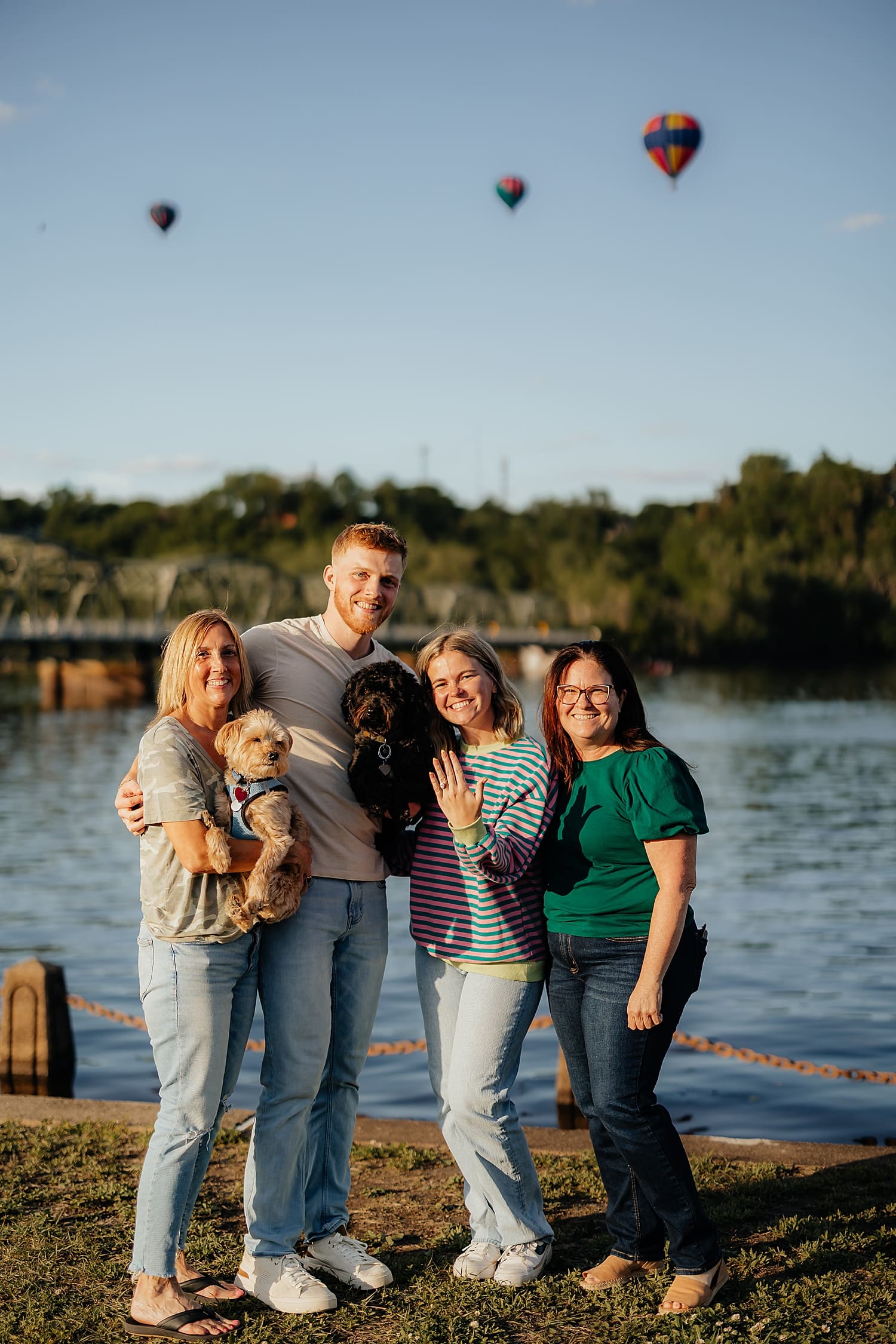 engaged couple stand with their moms by Wisconsin wedding photographer
