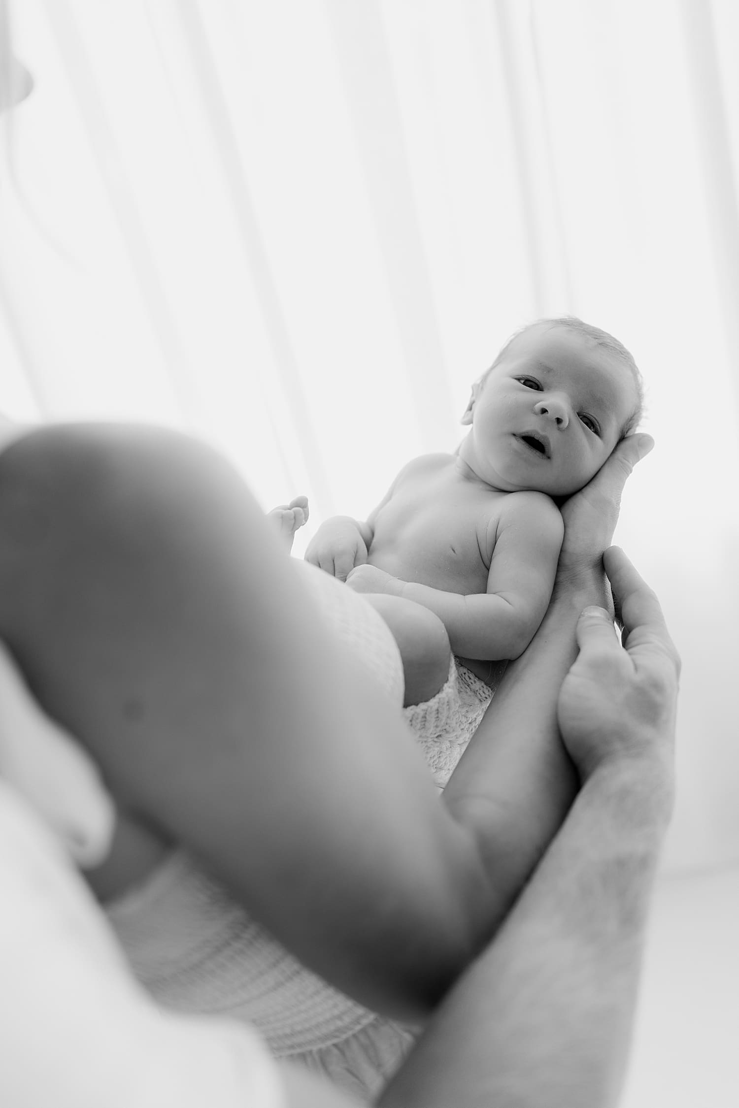 mother and father share holding their new bundle of joy by Wisconsin family photographer