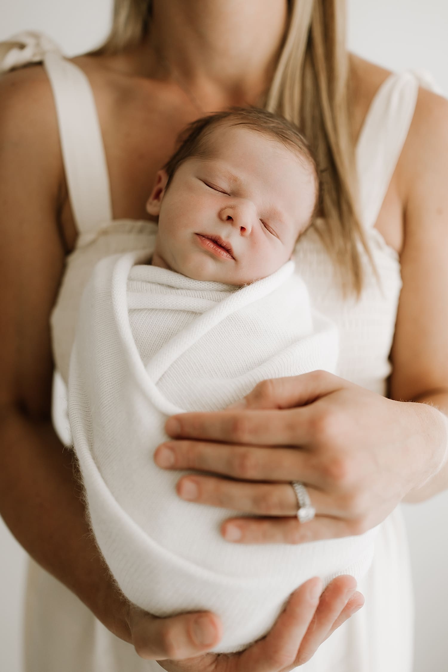 baby sleeps in mother's arms by Wisconsin family photographer