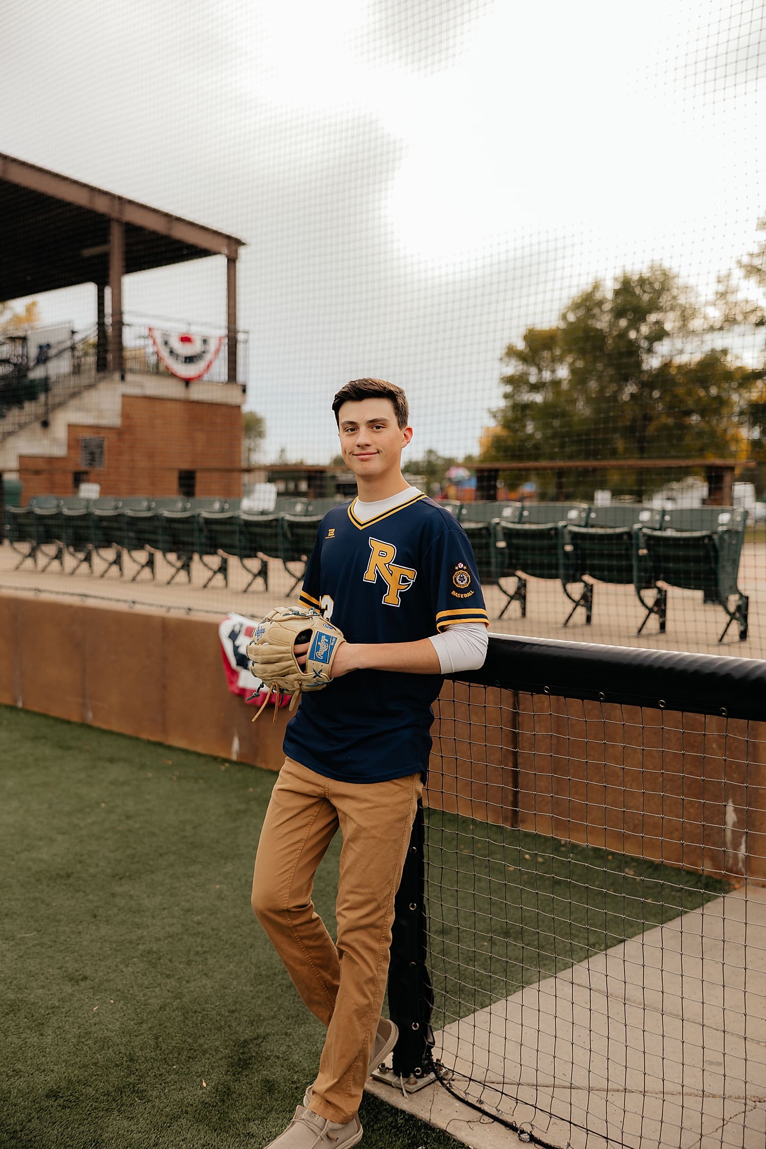 teenage boy leans against pit in field learning how to incorporate your hobbies in to your senior photos