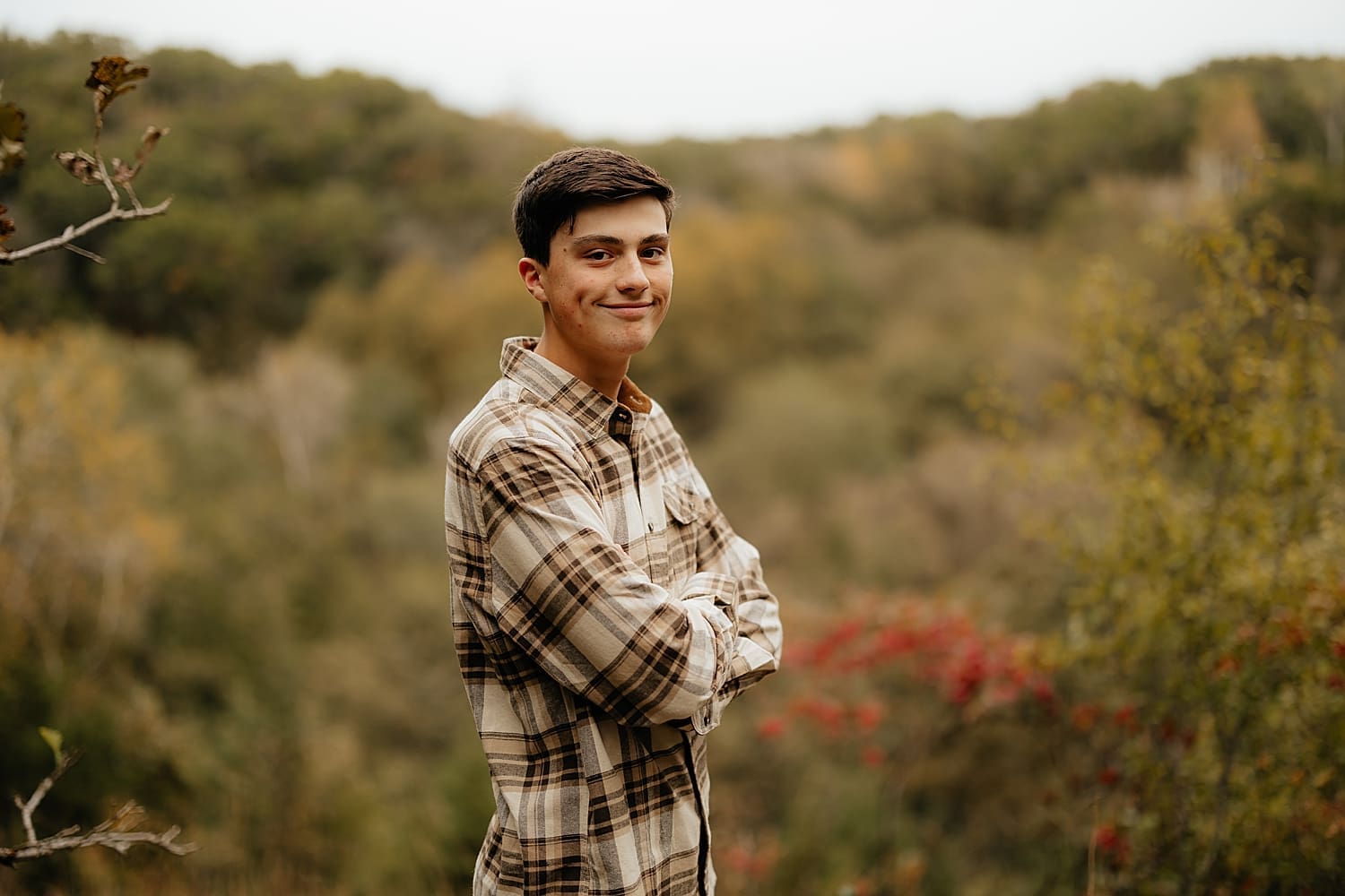 student wearing neutral shirt in front of trees by Rose and Oak Photography
