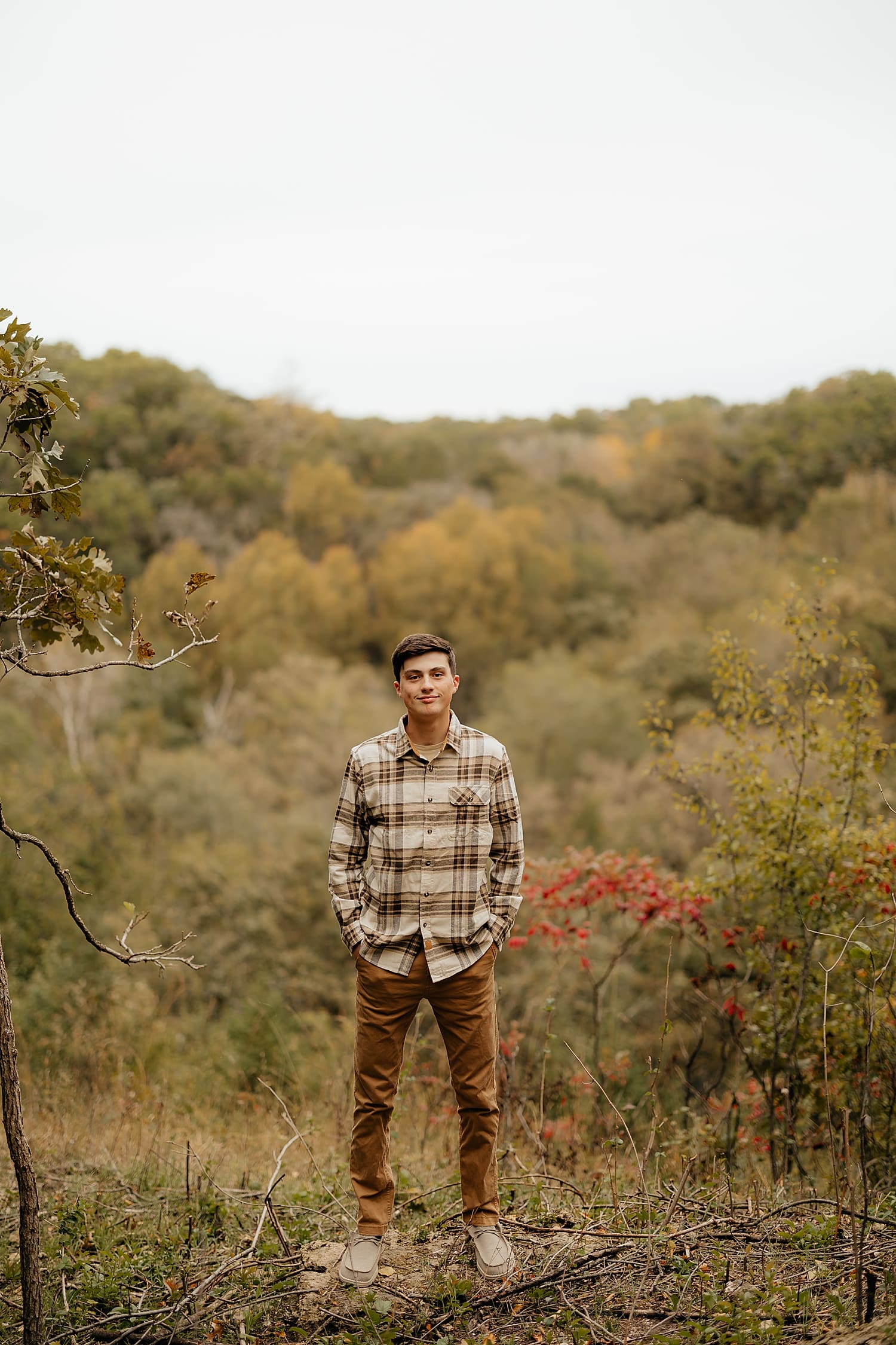 student wearing brown chinos and neutral shirt in forest by Wisconsin family photographer